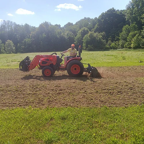 Austin-on-Tractor-tilling-ground.webp