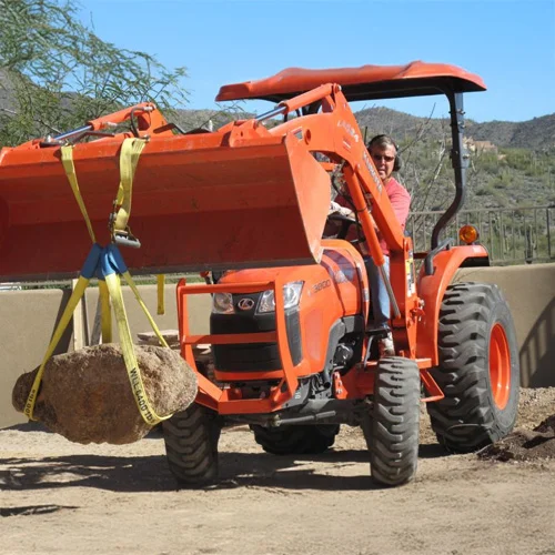 Utility-tractor-lifting-large-boulder.webp